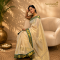 Cream and grey tissue saree flatlay with deep purple zari border and gold tassels