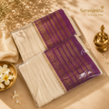 White saree with purple and gold zari border, gift packaged with jasmine flowers and brass lamp